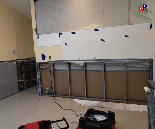 Fort Myers professional water damage cleanup showing exposed wall framing and drying equipment setup.png