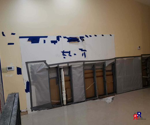 Water damage repair in Fort Myers with wall cutouts and containment setup during mold remediation process.png