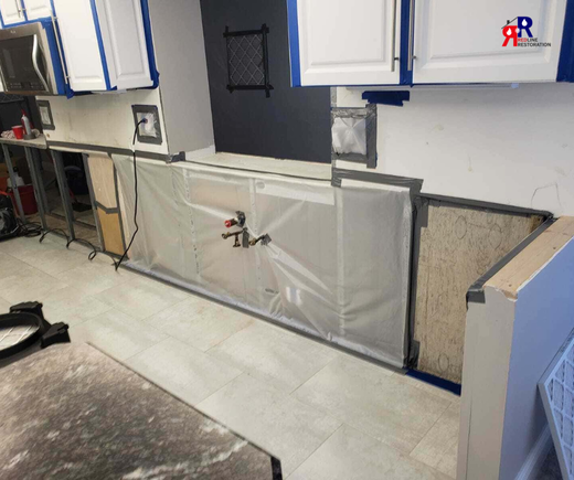 Water damage restoration underway in Fort Myers kitchen with drying equipment and cabinet repairs in progress.png